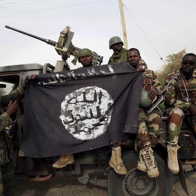 Nigerian soldiers hold up a Boko Haram flag that they had seized in the recently retaken town of Damasak, Nigeri