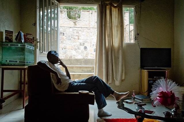 Tibagg, gay et activiste rwandais fume une cigarette dans le salon d'une amie dans un quartier de Kigali.