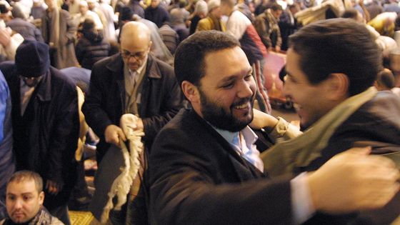 Deux personnes s'embrassent à l'issue de la prière marquant la fin du ramadan, l'Aid el Fitr. ©AFP - THOMAS WIRTH / AFP