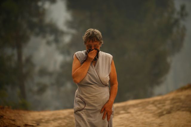 Une habitante de Oteiro, près de Sao Pedro do Sul, protège son visage de la fumée