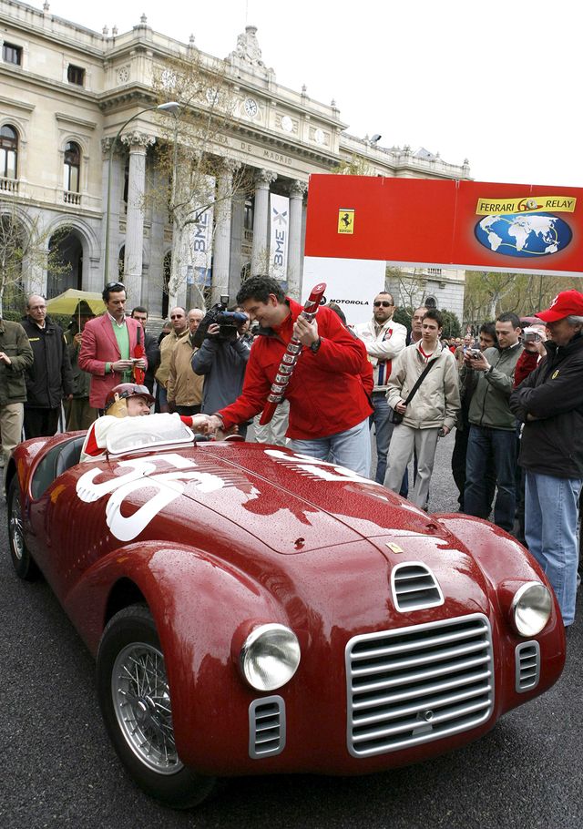 Andrea Costonovo, le directeur européen de Ferrari, reçoit un trophée d'un pilote assis à une Ferrari 125 S de 1948, sur la place Lealtad à Madrid le mercredi 4 avril 2007