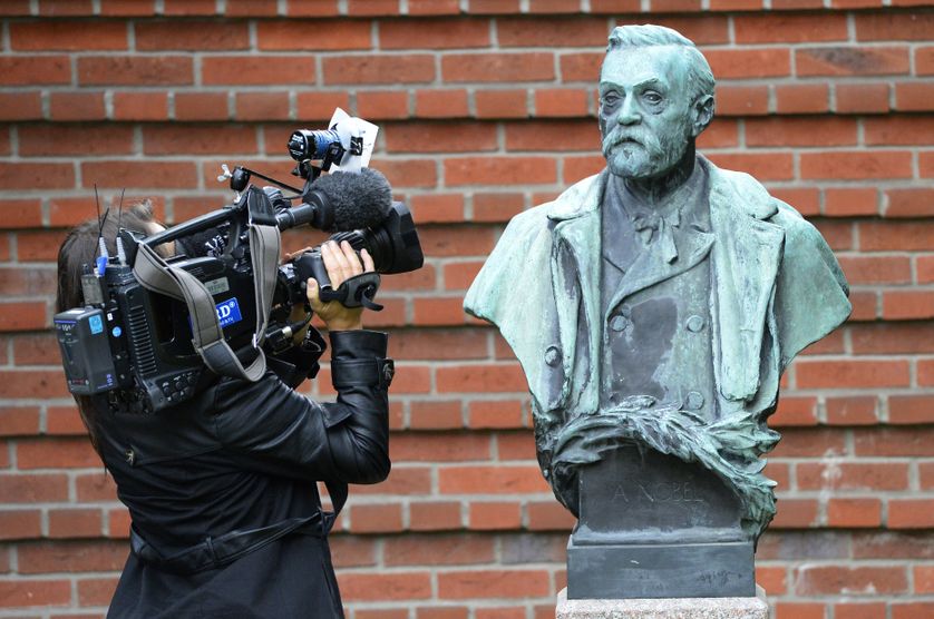 Une journaliste en train de filmer une statue du fondateur du prix Nobel, le Suédois Alfred Nobel, à Stockholm en octobre 2013.
