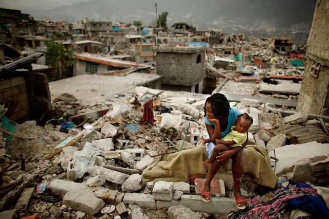 Sherider Anilus, 28 ans, et sa fille Monica, neuf mois, assises à l'endroit où leur maison s'est effondrée pendant le séisme de janvier 2010 dans le quartier national du Fort à Port-au-Prince, Haïti.