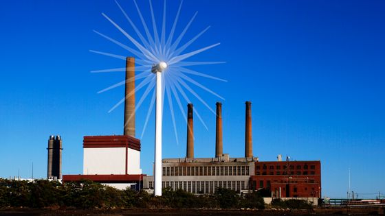 Une éolienne devant une centrale fonctionnant aux energies fossiles (Massachusetts, Etats-Unis ©Reuters - Brian Snyder