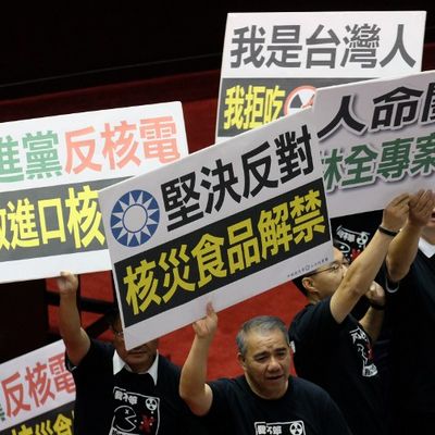 Legislators from the main opposition Kuomintang (KMT) display placards that read "Strongly oppose the lifting (of a) ban on nuclear polluted food from Japan" at the Parliament in Taipei, on November 18, 2016.