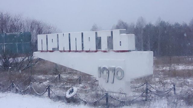 Panneau d'entrée Pripiat, ville créée en 1970 afin d'héberger les employés de la centrale nucléaire de Tchernobyl. Au pied, couronnes et bouquets.
