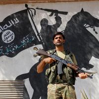 Soldat de l’armée syrienne libre devant une peinture murale de l’Etat islamique en Syrie, 31 août 2016