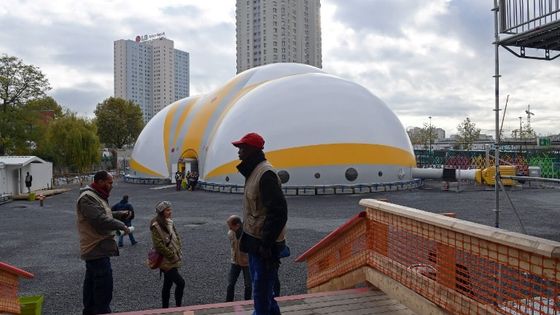 Des volontaires d'Emmaüs devant le camp bâti pour les migrants porte de la Chapelle, à Paris ©AFP - CHRISTOPHE ARCHAMBAULT