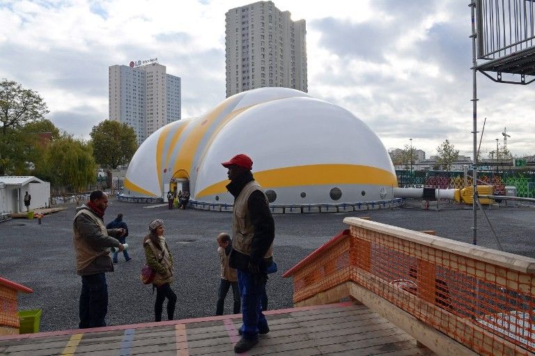 Des volontaires d'Emmaüs devant le camp bâti pour les migrants porte de la Chapelle, à Paris