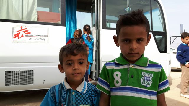 Deux enfants réfugiés devant le bus transformé par Médecins Sans Frontière en cabinet de psychologues dans le camp de Dibaga au sud de Mossoul.