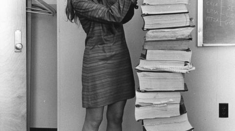 Margaret Hamilton devant le code qu'elle a écrit avec l'équipe du MIT pour la mission Apollo 11