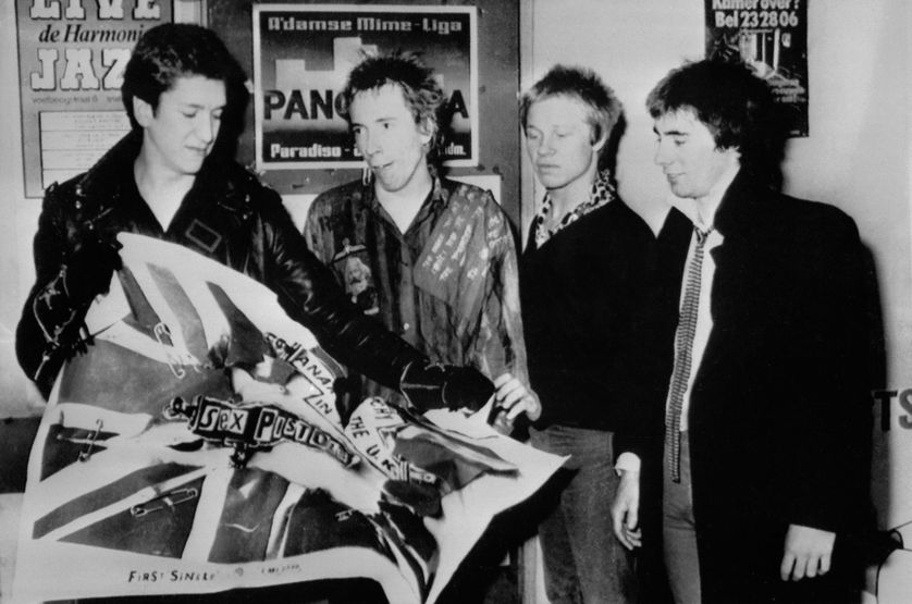 Les Sex Pistols déchirent un poster de leur premier single "Anarchy in the UK" paru en novembre 1976 chez EMI. Le 22 janvier 1977, la major annonce la fin de leur contrat. De g à d: Steve Jones, Johnny Rotten, Paul Cook et Glen Matlock