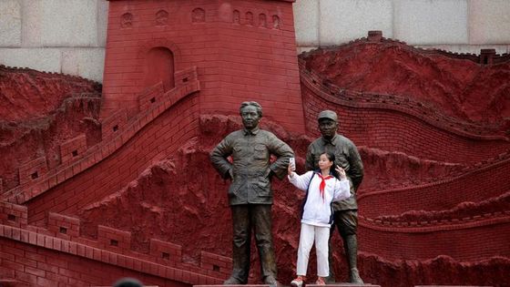Une femme prenant un selfie avec des statues représentant l'ancien président Mao Zedong et et l'ancien général Zhu De pendant la guerre contre le Japon. ©Reuters - Kim Kyuong Hoon