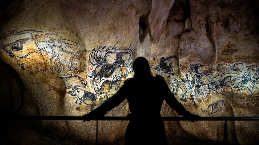 Une visiteuse contemple une reproduction de l'art pariétal de la grotte Chauvet.