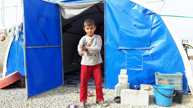 Un enfant réfugié avec sa famille dans une tente bleue de Nations Unies, dans le camp de Dibaga au sud de Mossoul.