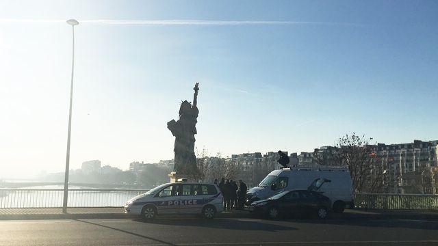 La police tente de retirer le voile noir qui recouvre le visage de la statue de la Liberté, à Paris