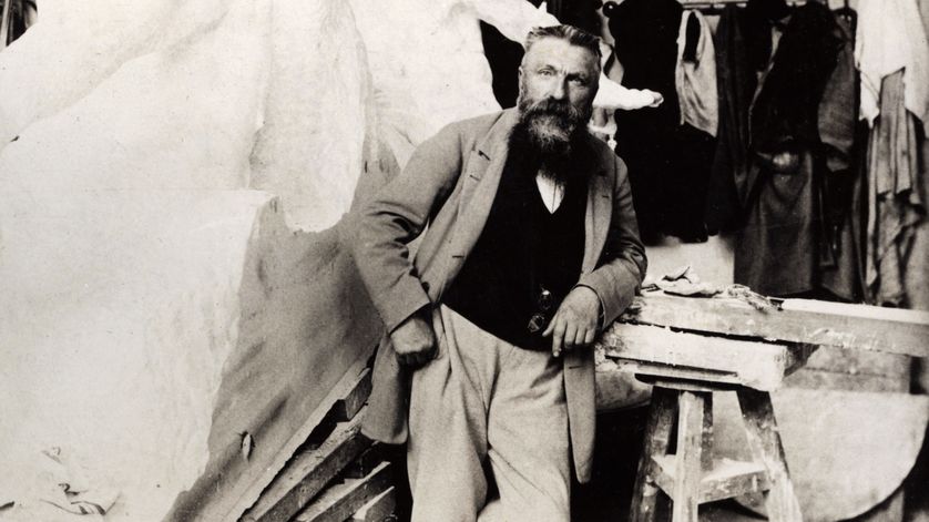 Photo d’Auguste Rodin dans son atelier à la fin des années 1890 avec la sculpture de Victor Hugo en arrière-plan.