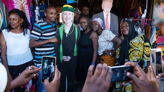 De jeunes tanzaniens posent en compagnie de photographies en grandeur nature des deux candidats à l'éléction présidentielle, lors d'un meeting organisé à l'ambassade américaine de Dar es Salaam, en Tanzanie il y a deux mois ©AFP - Daniel Hayduk
