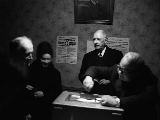 Le général de Gaulle (C) et son épouse (2eG) s'apprêtent à déposer leur bulletin de vote dans l'urne à la mairie de Colombey-les-Deux-Eglises, le 19 décembre 1965
