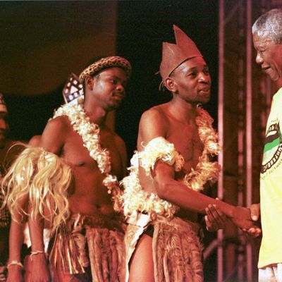 1997 à Mmabato, au nord de Johannesbourg : Nelson Mandela salue des danseurs zoulous lors du 50è congrès de l'ANC