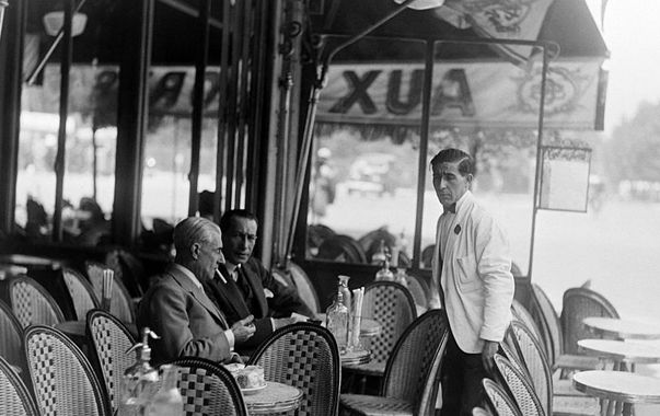 Maurice Ravel assis en terrasse d'un café parisien avec un ami, en 1930.