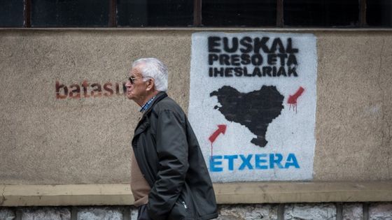 Un homme marche devant un graffiti de l'ETA à Saint Sébastien en Espagne ©AFP - Javi Julio Andalolu Agency