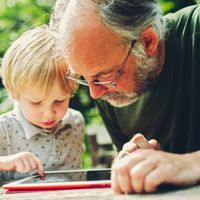 Echanges d'un grand-père avec son petit fils autour d'une tablette