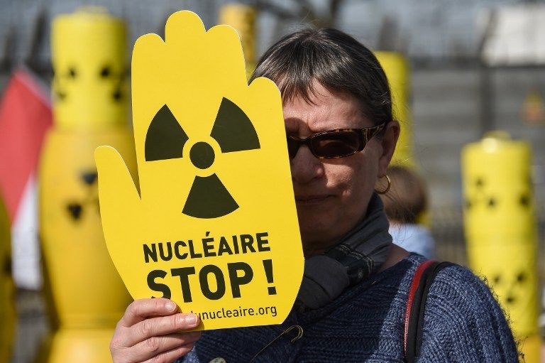 Une femme brandit une pancarte durant une manifestation pour la fermeture de la centrale de Fessenheim en mars 2017
