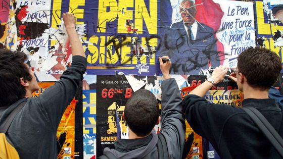 Des étudiants écrivent des slogans hostiles à Jean-Marie Le Pen sur des affiches électorales, le 22 avril 2002 à Lyon, lors d'une manifestation spontanée des étudiants ©AFP - JEAN-PHILIPPE KSIAZEK