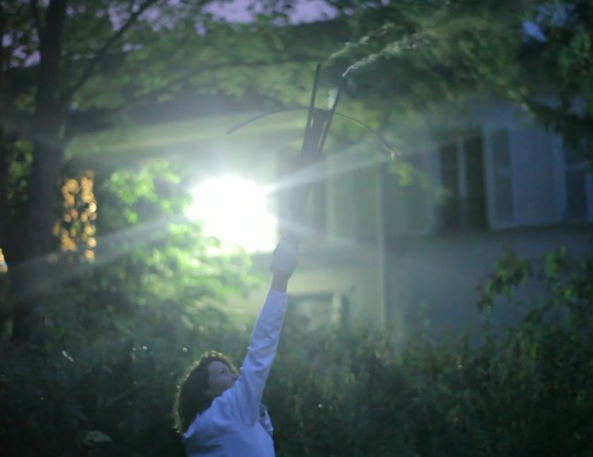 Performance Faire pleurer les nuages, Marie-Luce Nadal tirant à l'arbalète dans le jardin de la Cité des Arts (Montmartre)
