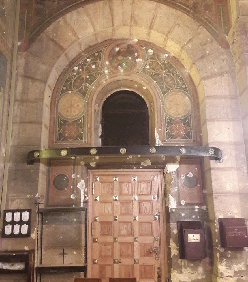 Porte d'entrée de l'Eglise de La Botroseya criblée de balles lors de l'attentat du 11 décembre 2016 revendiqué par le groupe Etat Islamique