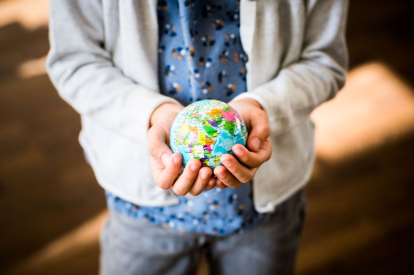 Une fille de 9 ans tenant un globe entre ses mains.