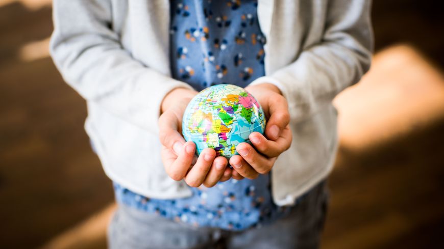 Une fille de 9 ans tenant un globe entre ses mains.
