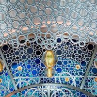 Détail du grand vitrail, où la lumière est diffractée par les milliers de cabochons de verre bleu et des cives or et ambre