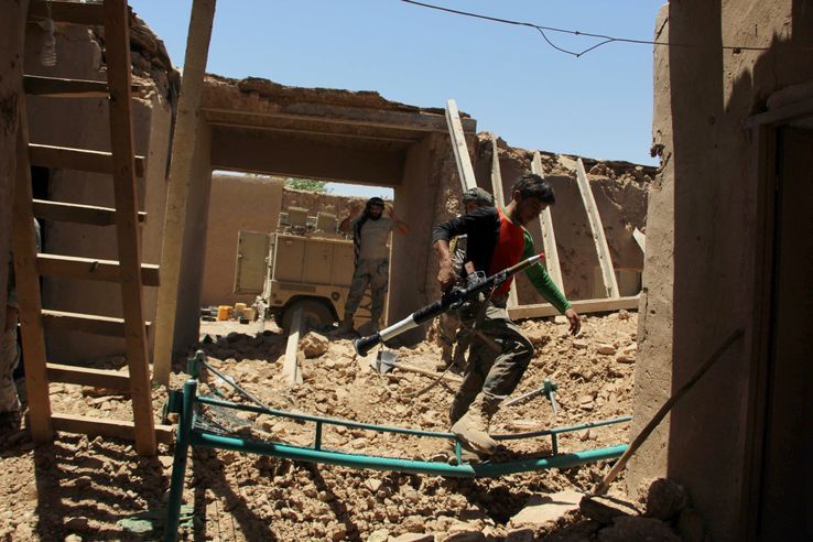 Des membres de la police des frontières afghane parcourent un avant-poste sévèrement endommagé par une frappe aérienne dans le quartier de Nad Ali dans la province d’Helmand, le 10 juin 2017.