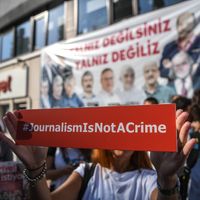 A journalist holds a banner on July 24, 2017 outside the headquarters of opposition daily newspaper Cumhuriyet in Istanbul.