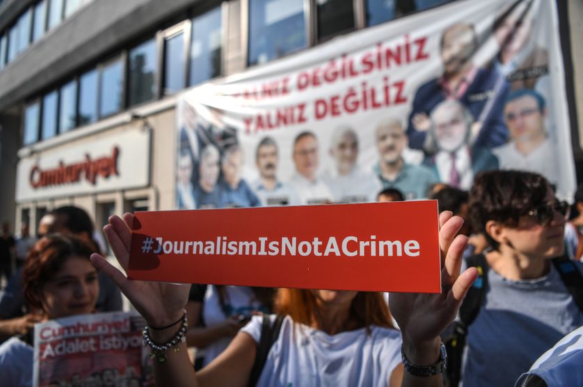 A journalist holds a banner on July 24, 2017 outside the headquarters of opposition daily newspaper Cumhuriyet in Istanbul.