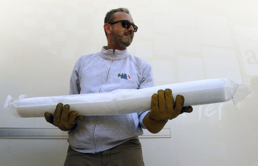 Jérôme Chappellaz, directeur de la recherche au CNRS porte une partie d'un noyau de glace, le 24 août 2016 à Chamonix, suite à l'extraction de deux carottes de glace extraites d'un glacier dans le cadre du projet « Protéger la mémoire des glaces ».