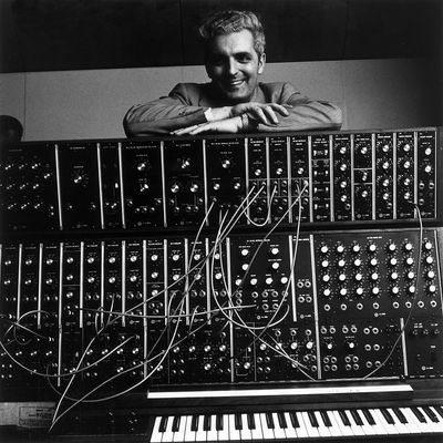Janvier 1970 : Portrait de l'inventeur Robert Moog, souriant et les bras croisés sur son synthétiseur Moog