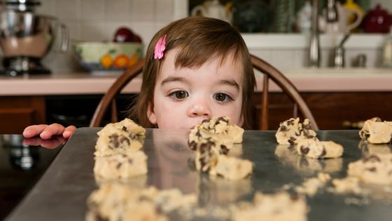 Portrait d'une enfant, regardant avec envie des cookies. ©AFP - ZAVE SMITH / IMAGE SOURCE