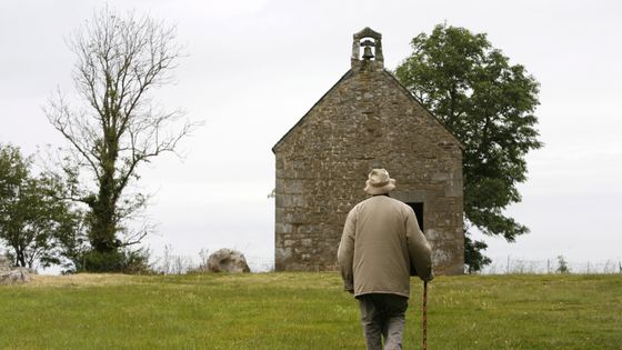 Homme marchant jusqu'à la chapelle de Mont-Dol en France ©AFP - PHILIPPE LISSAC / LEEMAGE