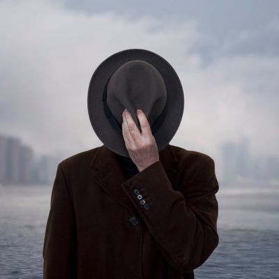 Portrait d'un homme avec le visage couvert par un chapeau.