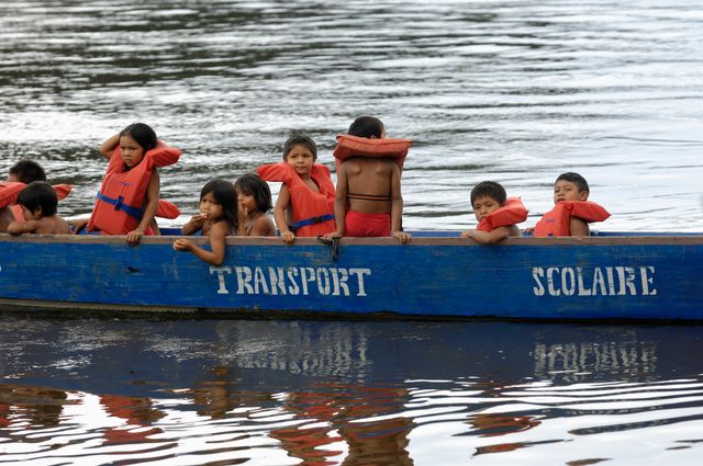 Des enfants de la tribu Wayana, du village de Twenke qui vont à l'école dans une barque, sur la rivière Maroni.