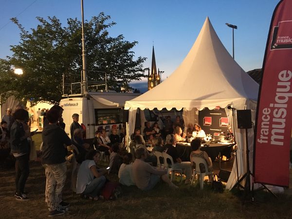 Le public se rassemble devant la tente France Musique, alors qu'on rediffuse un concert de la veille en attendant (impatiemment) celui du soir.
