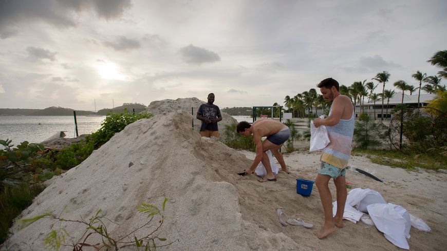 Les employés d'un hôtel à Saint-Martin disposent des sacs de sable avant l'arrivée d'Irma