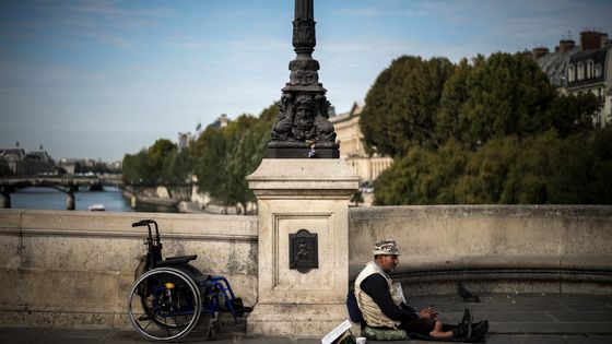 Un sans-abri assis sur le sol d'un pont de Paris, le 29 septembre 2017 ©AFP - Lionel BONAVENTURE