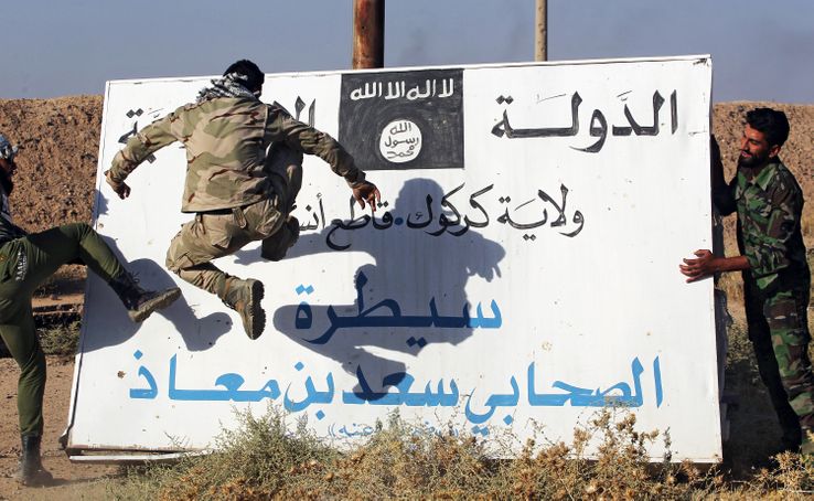 Des hommes d'"unités de mobilisation populaire" (Hachd al-Chaabi) s'en prennent à un panneau de l'EI à Hawija, en Irak, le 6 octobre 2017
