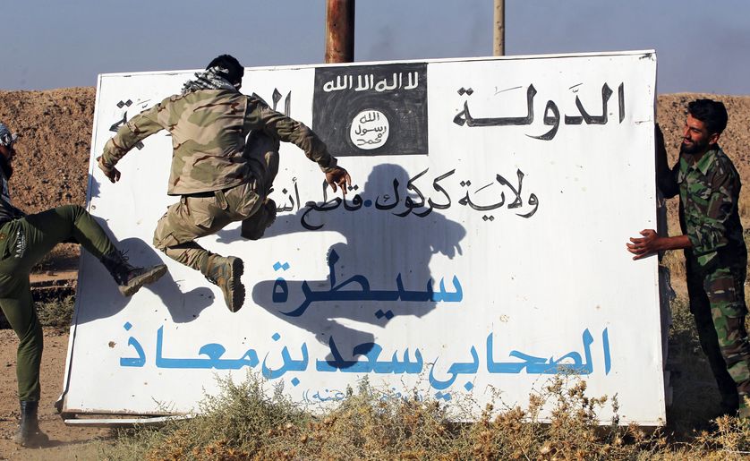 Des hommes d'"unités de mobilisation populaire" (Hachd al-Chaabi) s'en prennent à un panneau de l'EI à Hawija, en Irak, le 6 octobre 2017