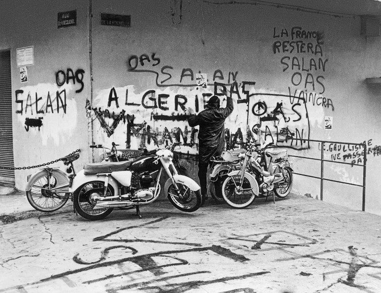 Photo prise le 04 mars 1962, pendant pendant la guerre d'Algérie, d'un homme lisant des graffitis en faveur de l'OAS, l'organisation de l'armée secrète prônant l'Algérie française, sur un mur d'une rue d'Alger.