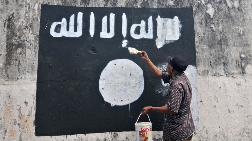 Un fonctionnaire indonésien efface les drapeaux de l’Etat islamique peints sur les murs de la ville de Surakarta (Java).